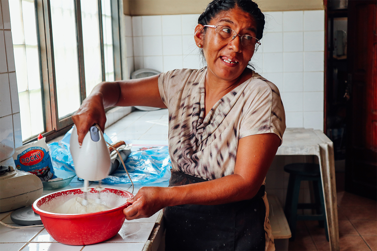 Lucy mixes cake batter in the kitchen of the church in Bolivia where she works. As the mother of a sponsored child, she learned to be a baker through her local Unbound mothers group. 